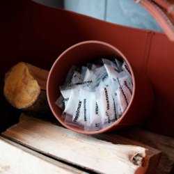 Cylinderbeholder til briketter i lder - sort med hvide syninger